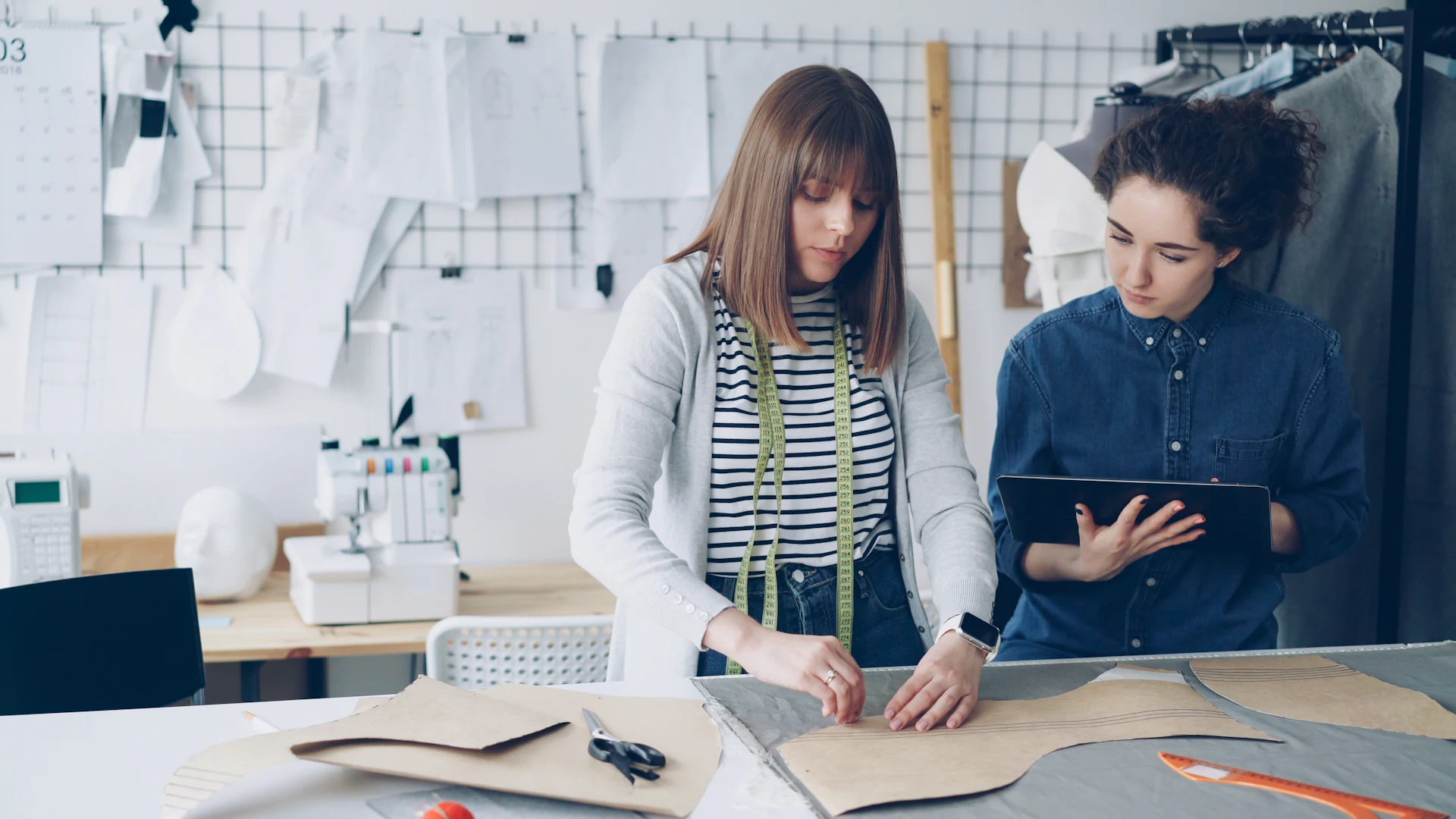 Fashion designer cutting a paper pattern in a clothing design studio