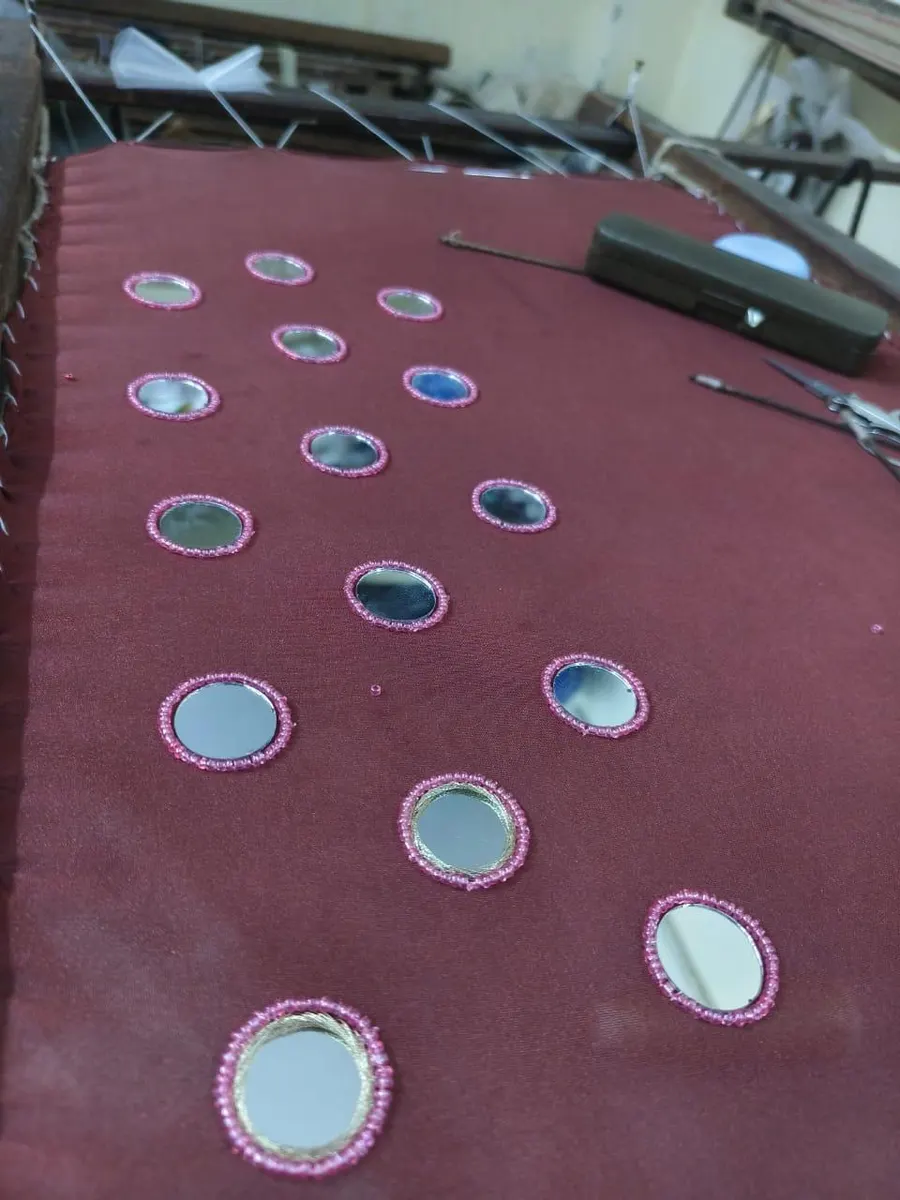 Mirror work embroidery on maroon fabric