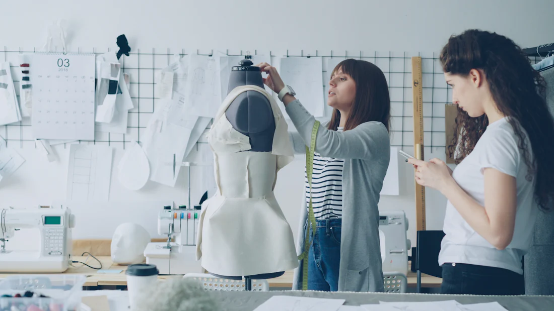 Designer fitting a sample on a dress form