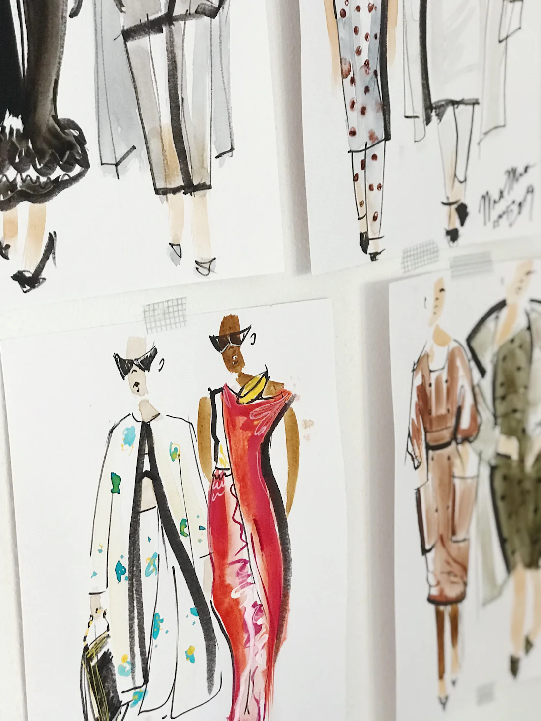 Fashion illustrations pinned to a board