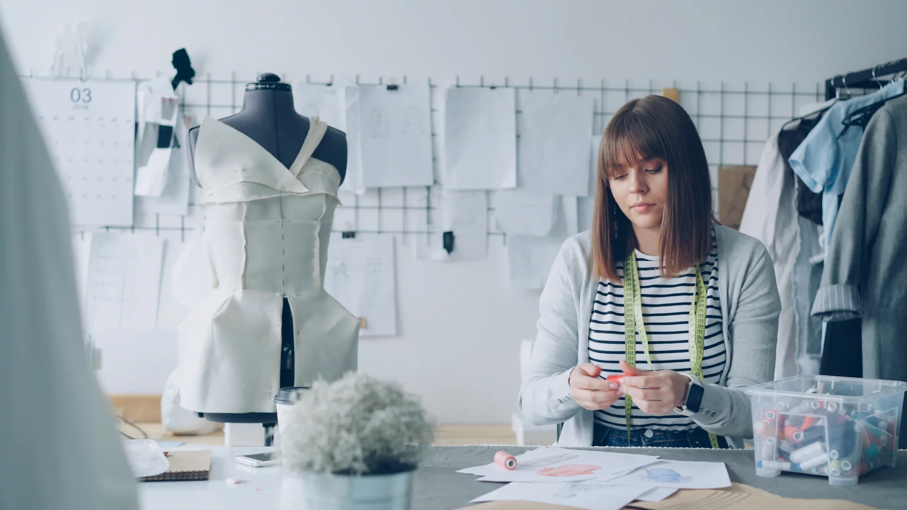 Fashion designer sketching garment designs at a studio desk