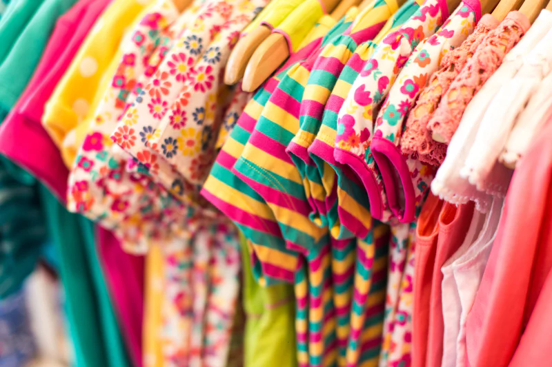 Colourful kids clothes on hangers